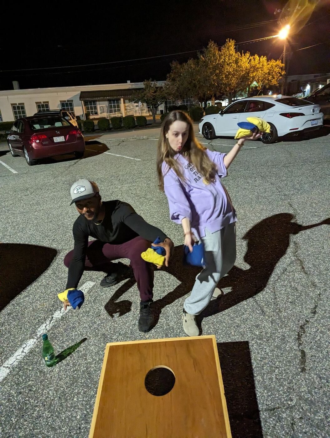 A parking-lot cornhole break, mid-marathon